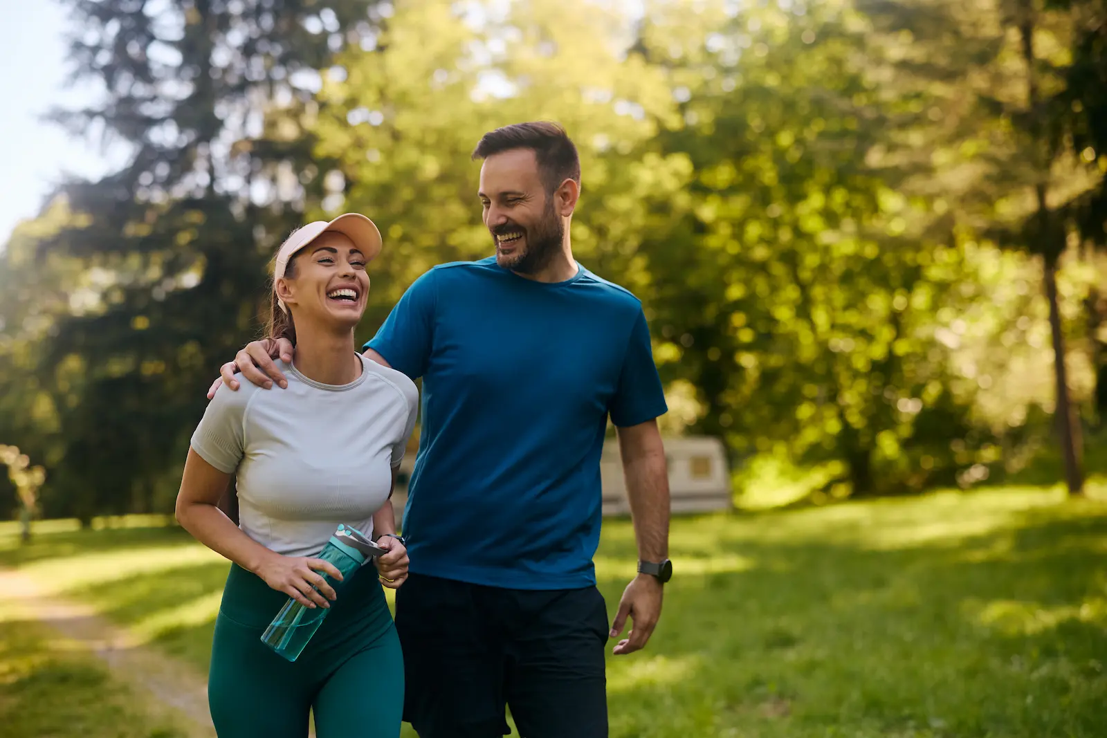 A couple walking together through a sunlit park
